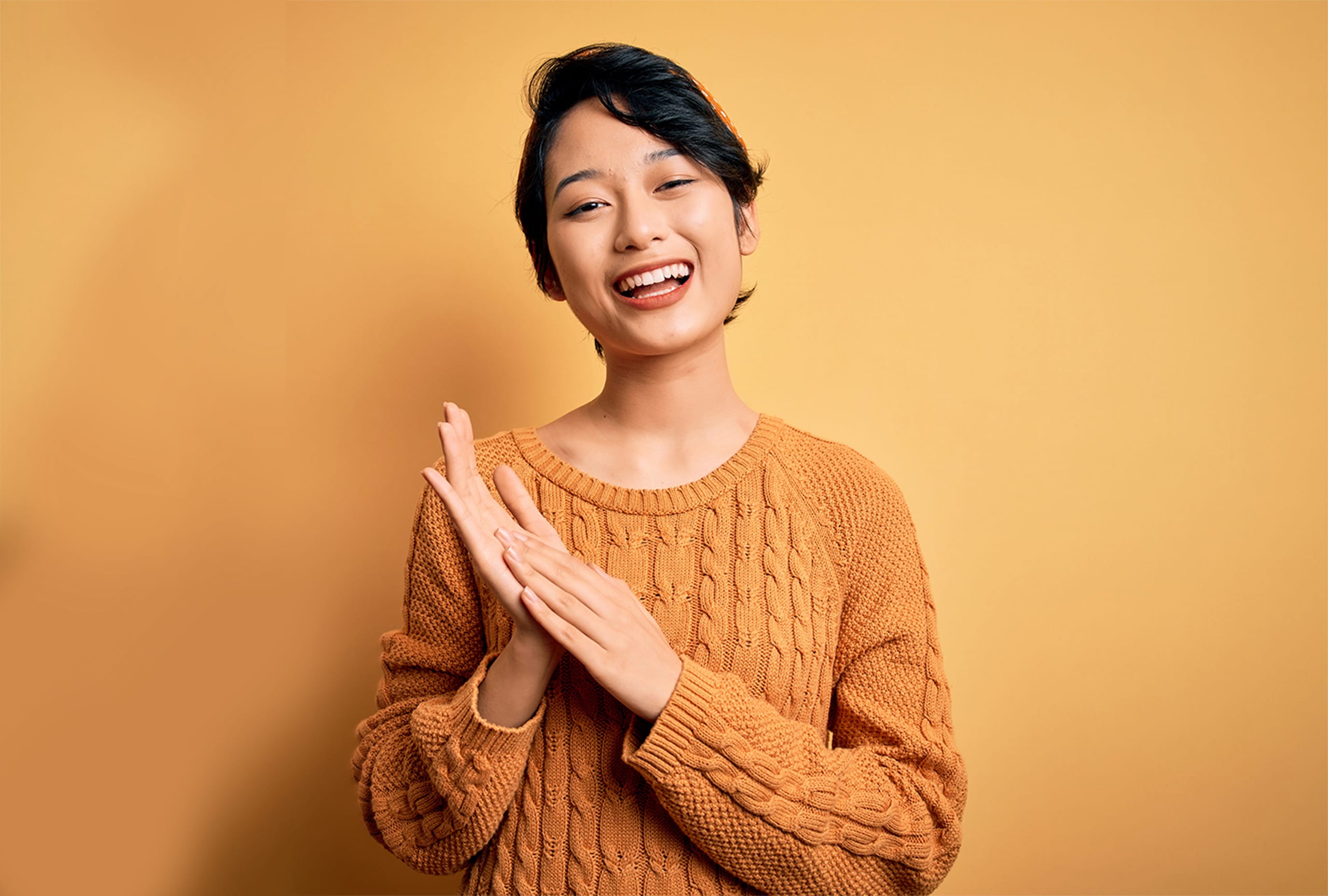 Beautiful Asian girl in a yellow sweater smiling
