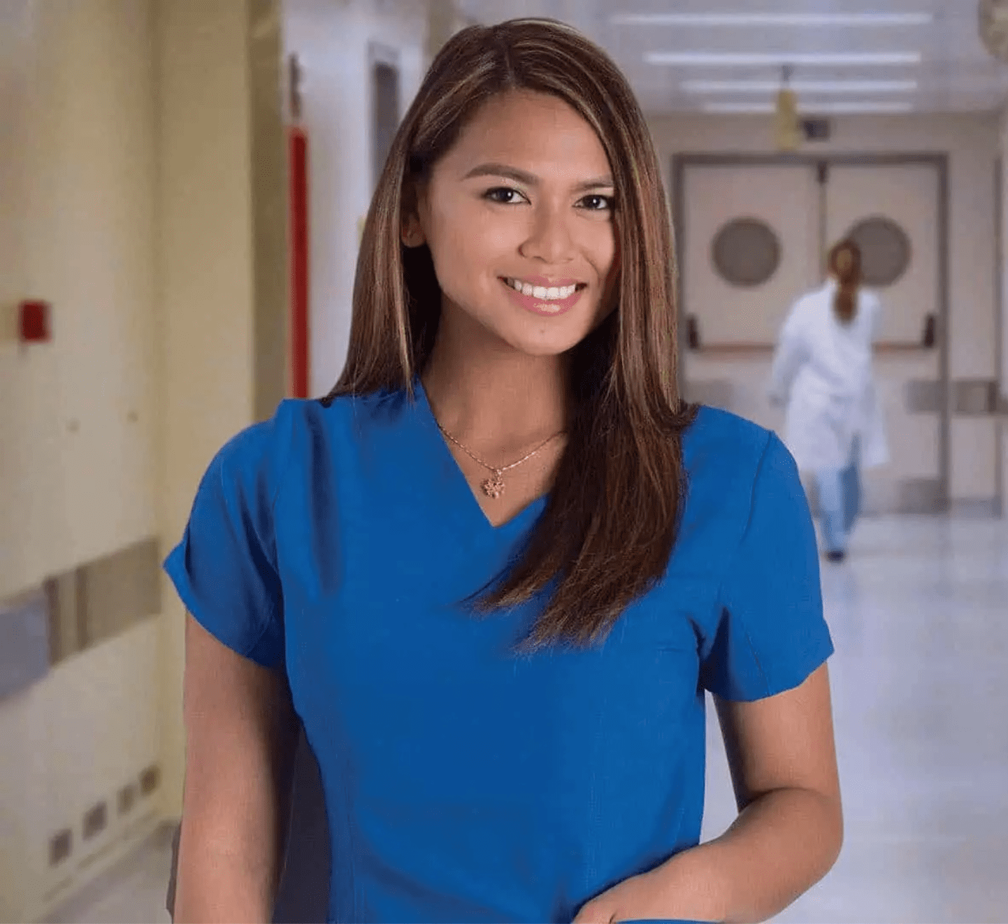 Asian female wearing blue scrubs and smiling