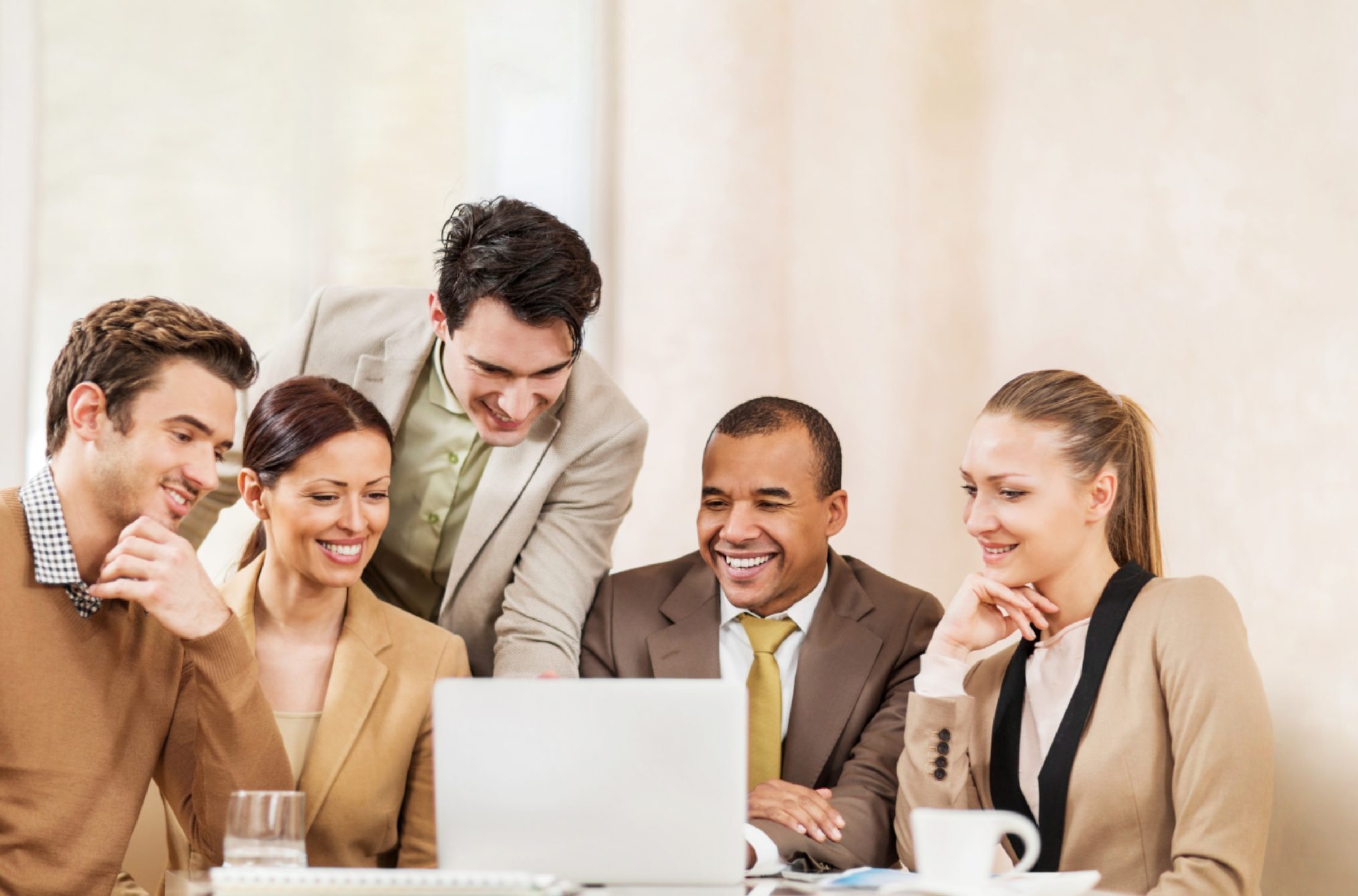 People gathered around computer smiling | Emily Chow Marketing