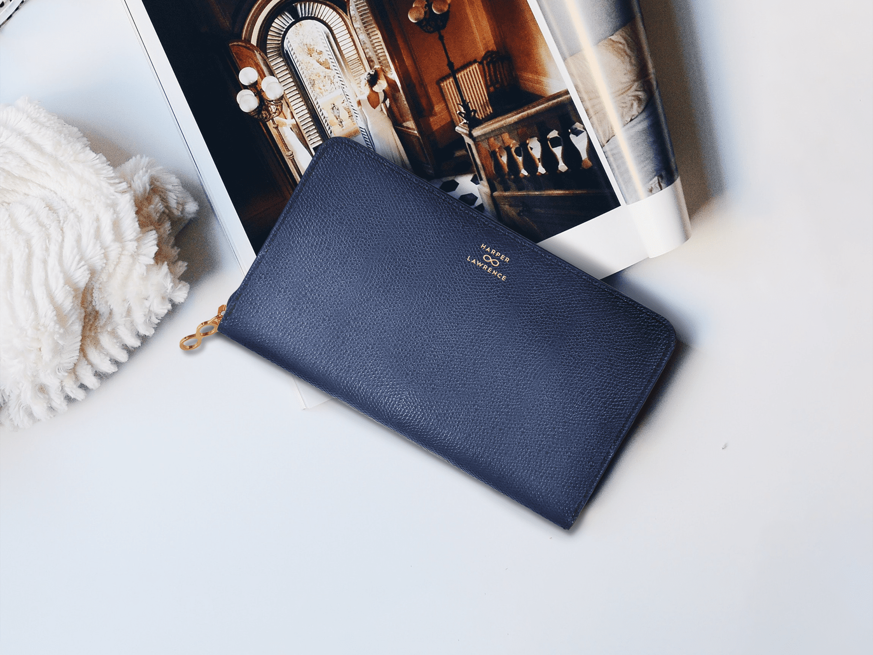 Navy clutch from Harper Lawrence placed on a fashion magazine