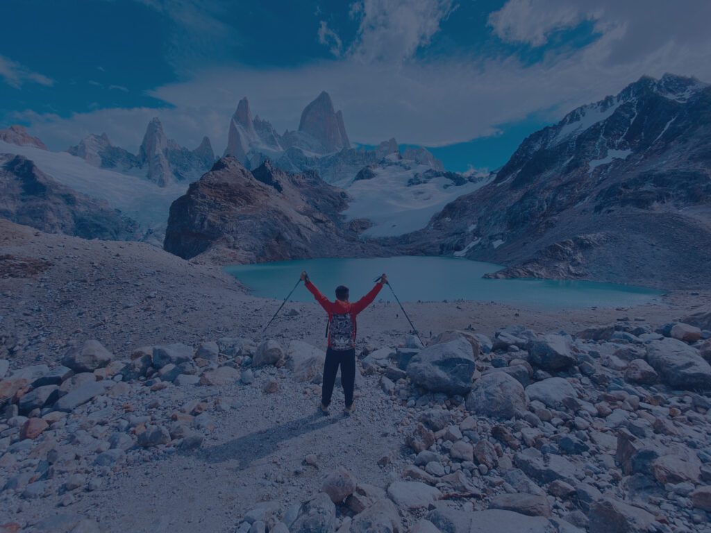 Dark blue image of triumphant man hiking in the mountains