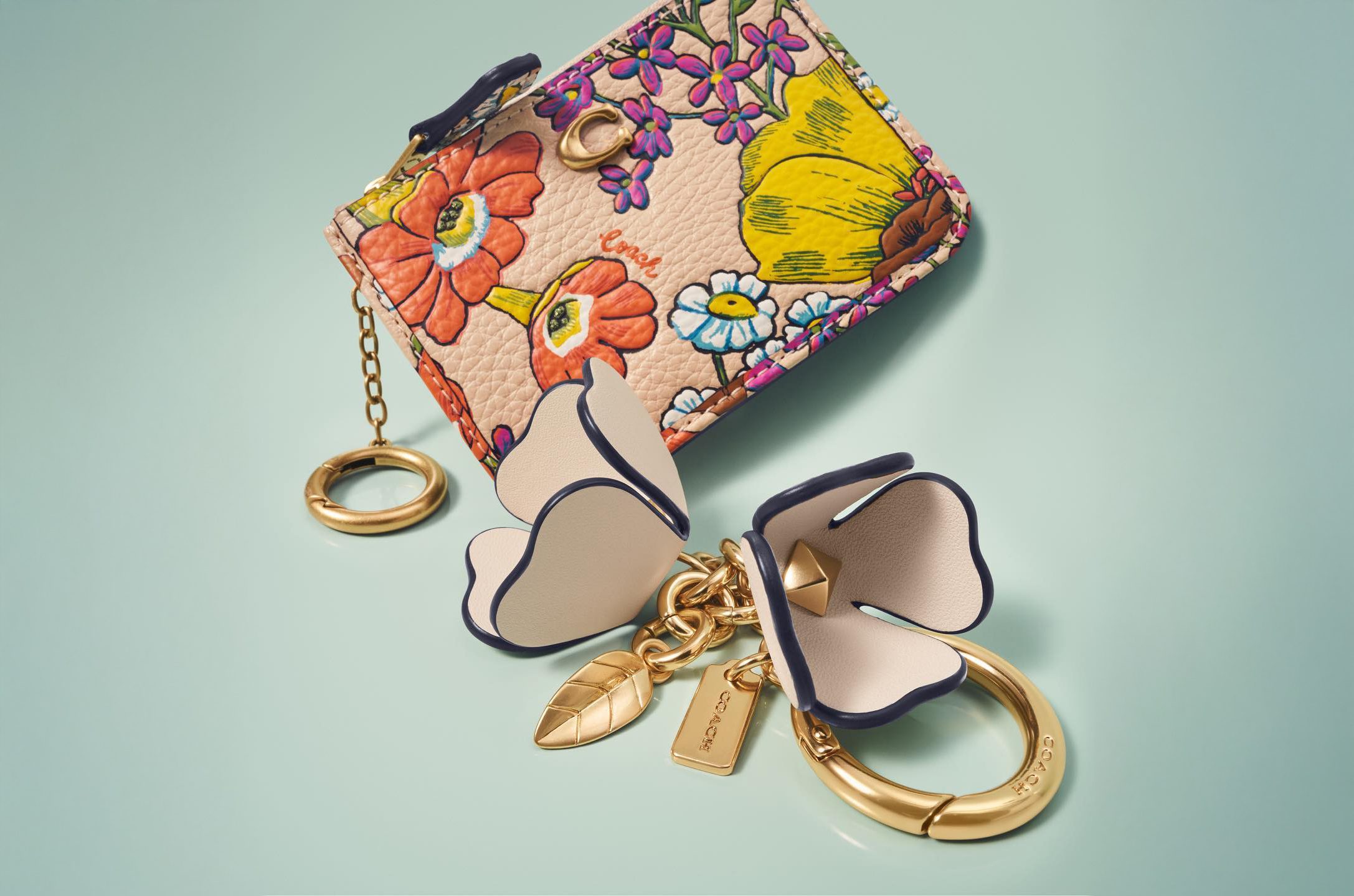 Floral print Coach hand bag on a light green background